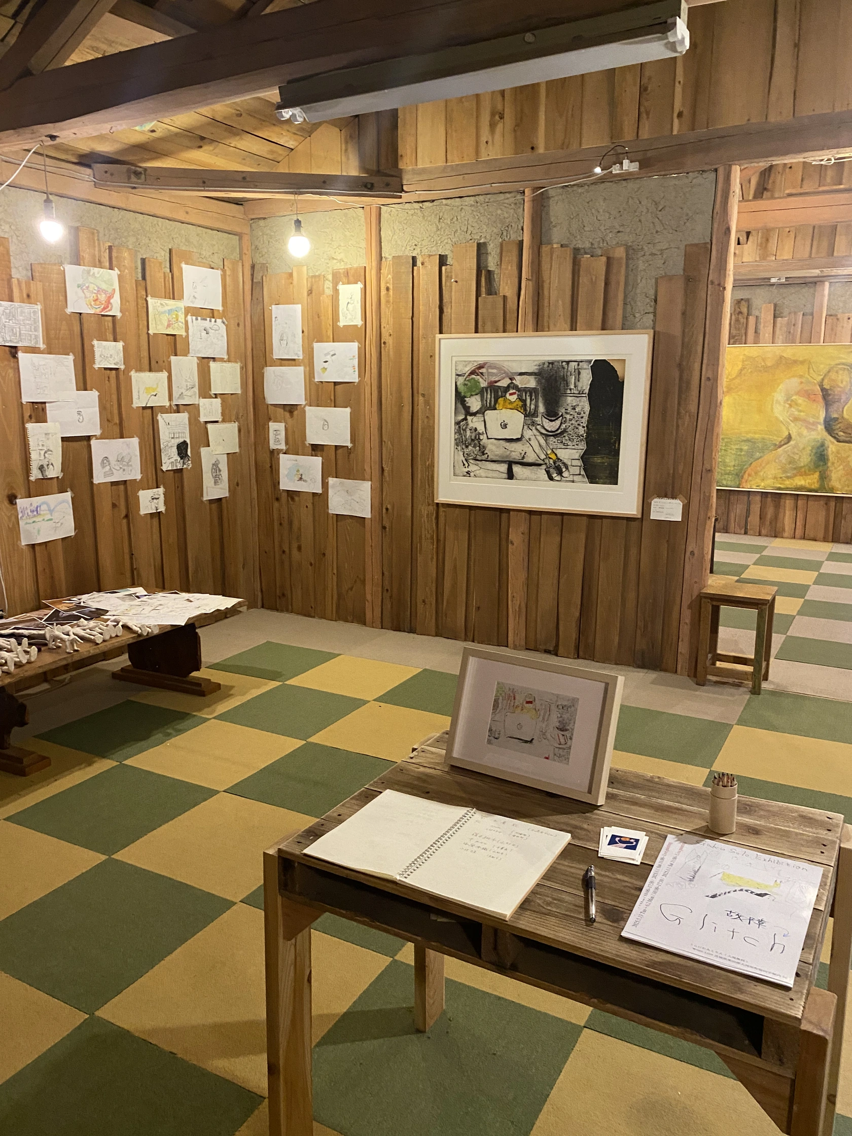 木の壁と緑と黄の床の展示空間