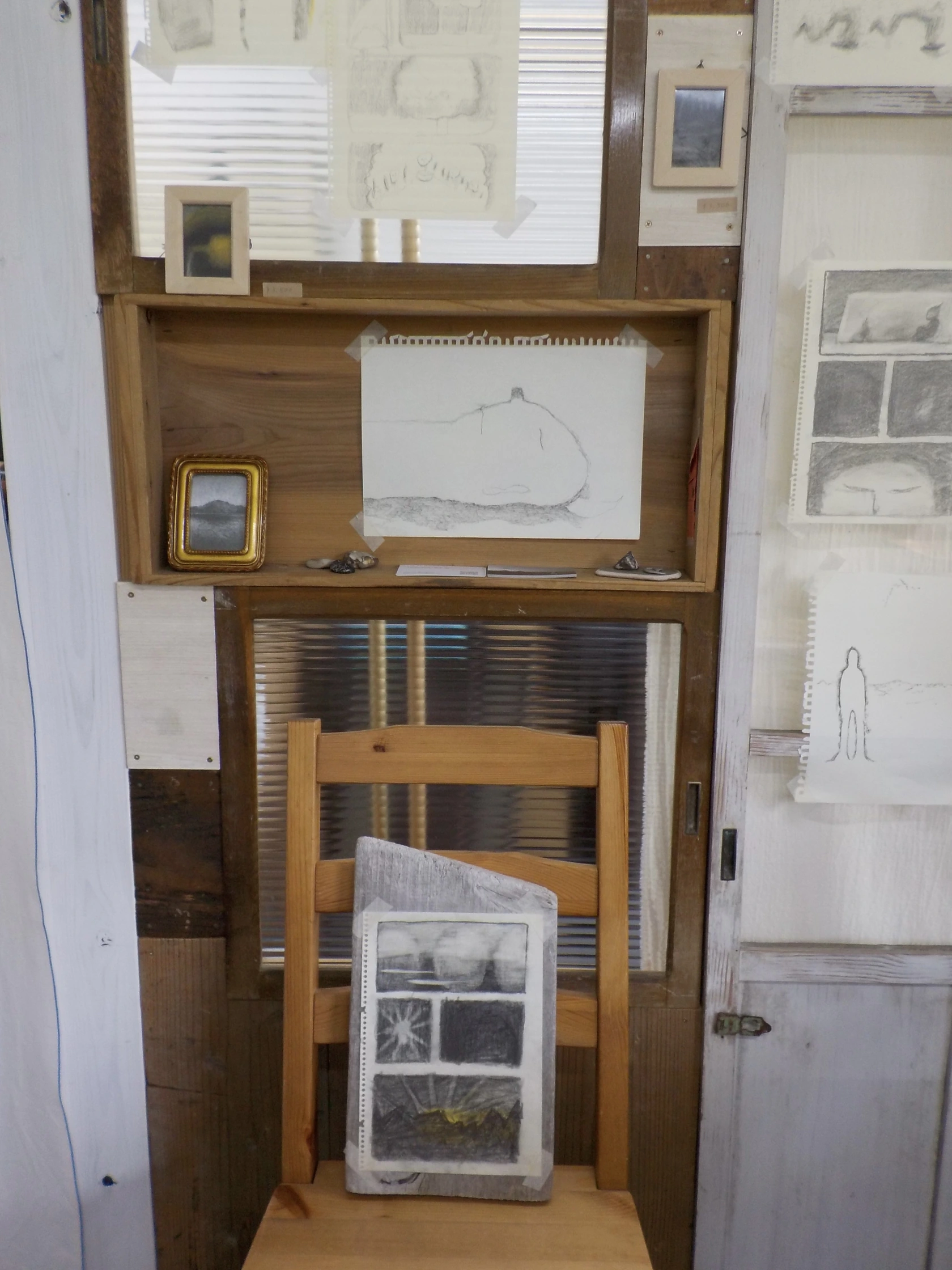 木の建具と椅子に並べられた素描
