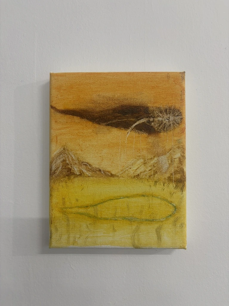 黄色い風景に、山並みと光をまとった人の姿を描いた作品